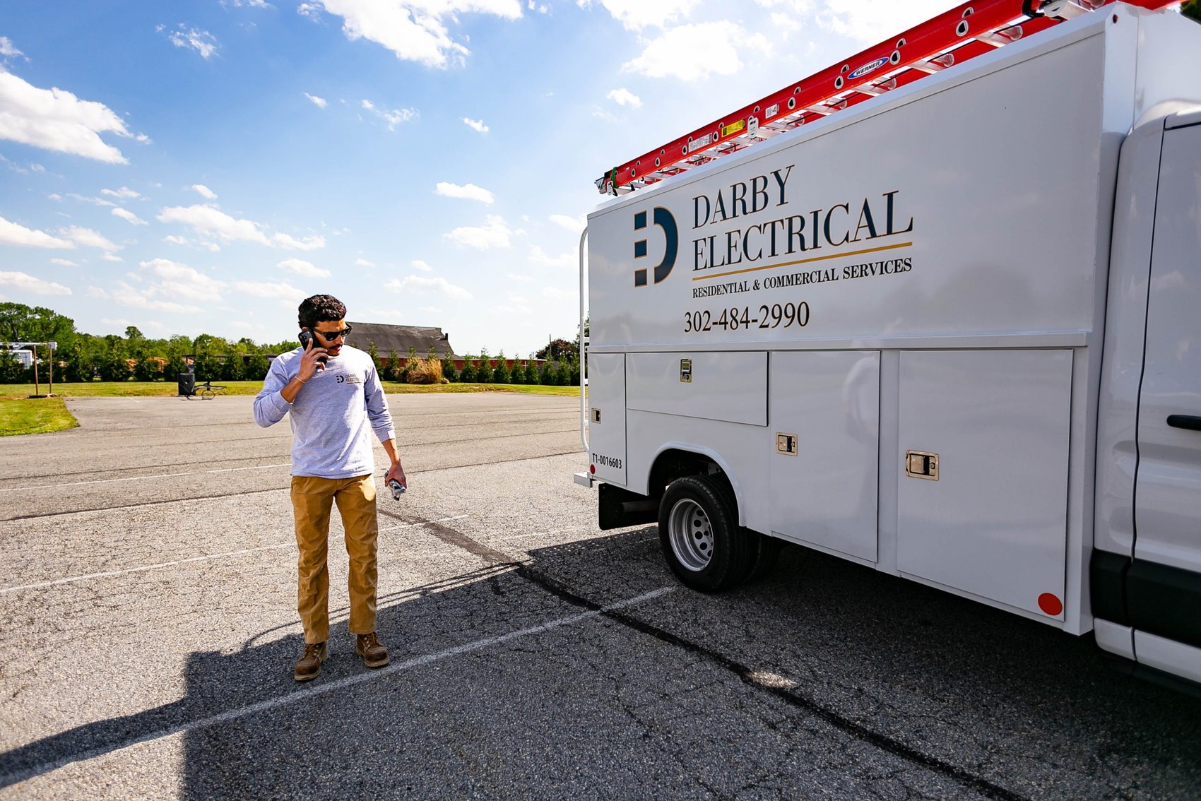 William Darby Jr., owner of Darby Electrical, on the phone beside a company service truck with the name and number on it